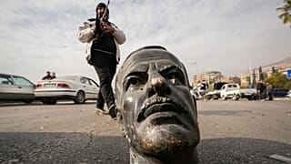 Боевик рядом с разбитым бюстом Хафеза Асада, отца и предшественника Башара Асада, Дамаск, 8 декабря 2024 года.