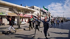 سوريون يحتفلون بسقوط حكومة بشار الأسد في بلدة بر الياس، لبنان، بالقرب من الحدود مع سوريا، الأحد 8 ديسمبر 2024. 