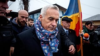 Calin Georgescu, an independent candidate for president who won the first round of presidential elections, leaves after speaking with media outside a voting station.