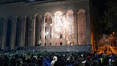 Διαδηλωτές εκτοξεύουν κροτίδες στο Κοινοβούλιο κατά τη διάρκεια διαμαρτυρίας για την απόφαση της κυβέρνησης να αναστείλει τις διαπραγματεύσεις για την ένταξη στην Ευρωπαϊκή Ένωση στην Τιφλίδα