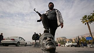 یکی از شورشیان مخالف حکومت سوریه و مجسمه سرنگون شده حافظ اسد