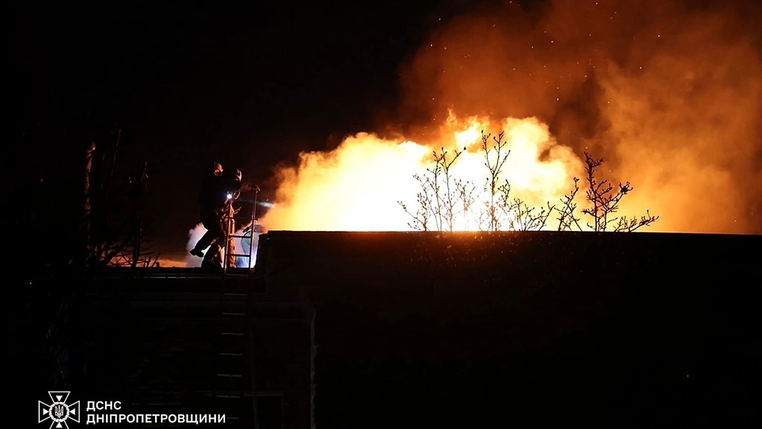 Sur cette photo fournie par les services d'urgence ukrainiens le 21 novembre 2024, des secouristes éteignent un incendie causé par un tir de missile russe à Dnipro.