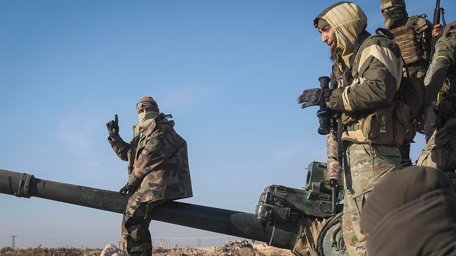 Suriye muhalif militanlar, Hama kentinin dış mahallelerinde ele geçirilen askeri zırhlı aracın üzerinde duruyor