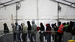 Migrants and refugees line up at the central registration center for refugees and asylum seekers LaGeSo (Landesamt fuer Gesundheit und Soziales - State Office for Health and S