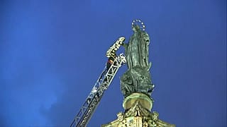 Pompier déposant une couronne de fleurs sur le bras de la statue de la Vierge Marie, à Rome en Italie, le 08.12.2024