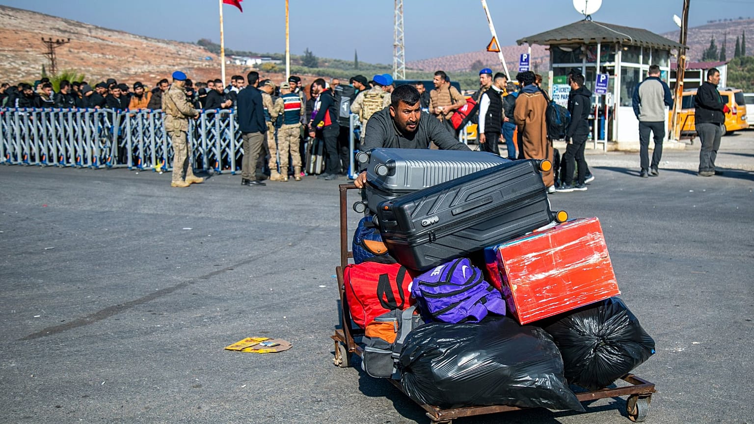 Suriyeliler, 9 Aralık 2024 Pazartesi günü Türkiye'nin güneyindeki Antakya kenti yakınlarındaki Cilvegözü sınır kapısından Türkiye'den Suriye'ye geçmek için geliyor.