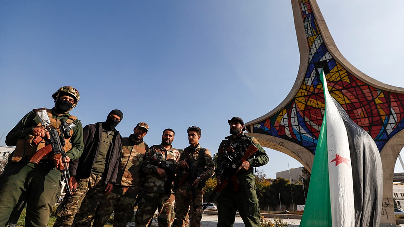 مقاتلو المعارضة السورية يقفون لالتقاط صورة أثناء احتفالهم في ساحة الأمويين في حلب، سوريا، الاثنين، ديسمبر 9 تشرين الثاني 2024. 