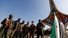 مقاتلو المعارضة السورية يقفون لالتقاط صورة أثناء احتفالهم في ساحة الأمويين في حلب، سوريا، الاثنين، ديسمبر 9 تشرين الثاني 2024. 