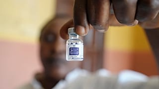 Un operatore sanitario mostra un flacone di vaccino contro la malaria prima di somministrarlo a un bambino in Nigeria, dicembre 2024