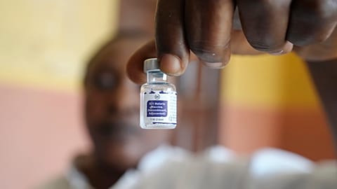 A health worker shows a bottle of the malaria vaccine before administering it to a child in Nigeria in December 2024.