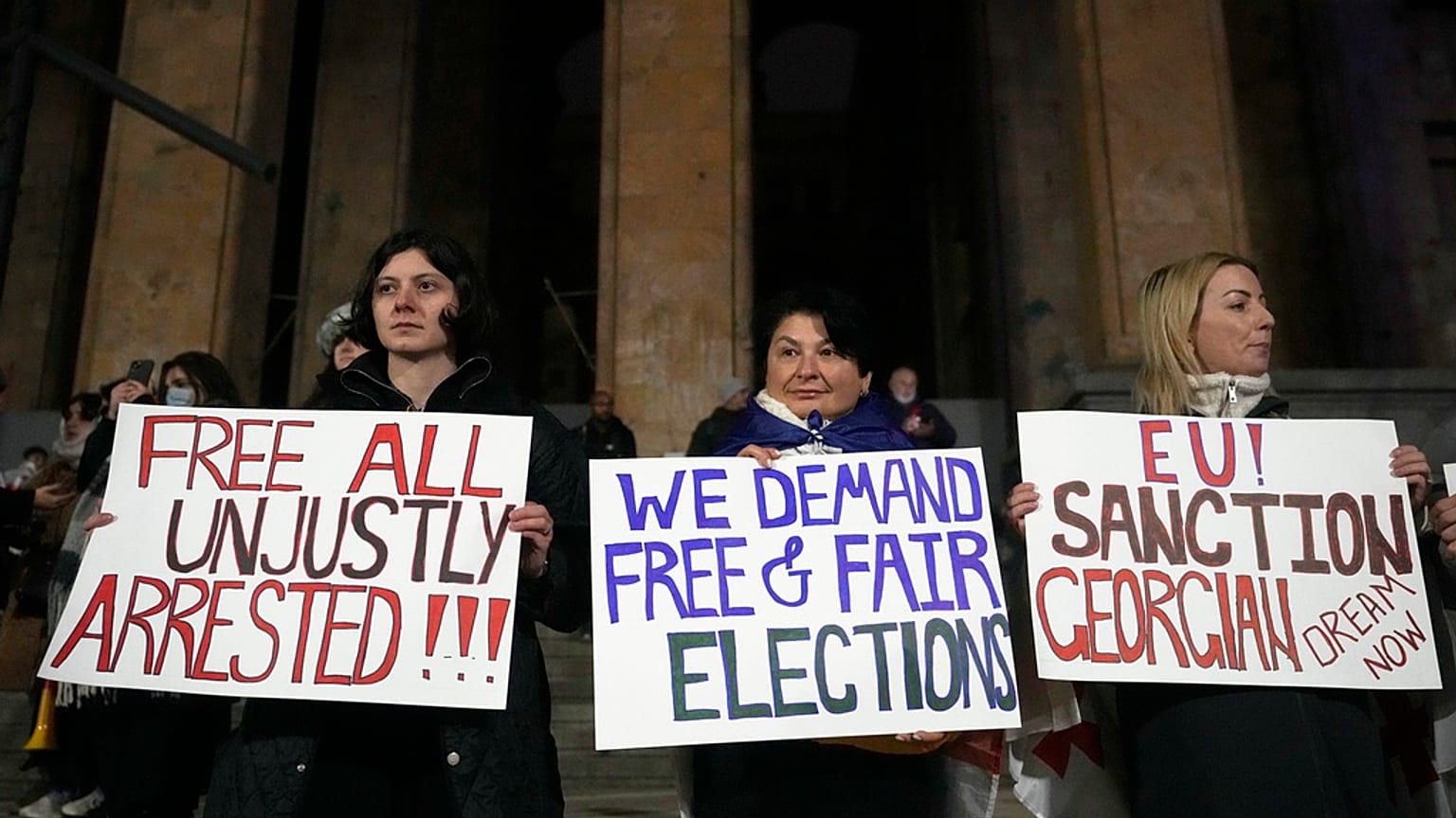 Manifestantes protestan frente al edificio del Parlamento en rechazo a la decisión del Gobierno de suspender las negociaciones sobre la adhesión del país a la UE.
