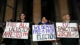 Manifestantes protestan frente al edificio del Parlamento en rechazo a la decisión del Gobierno de suspender las negociaciones sobre la adhesión del país a la UE.