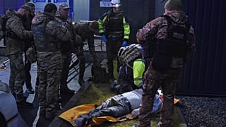 Ratownik medyczny bada ciało zabitej osoby po tym, jak rosyjska rakieta uderzyła w prywatną klinikę medyczną w Zaporożu, Ukraina.