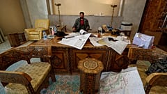 معارض سوري يجلس داخل مكتب في القصر الرئاسي بعد انهيار الحكومة السورية في دمشق، سوريا، يوم الأحد 8 ديسمبر/كانون الأول 2024