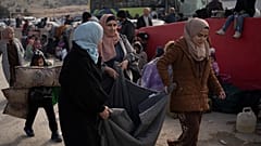 سوريون ينتظرون على الطريق للعبور إلى لبنان بالقرب من معبر المصنع الحدودي، كما يظهر من شرق لبنان، الأربعاء، 11 ديسمبر/كانون الأول 2024