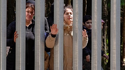 مجموعة مكونة من حوالي 30 مهاجرًا يطلبون اللجوء في بيالوفيزا، بولندا، يوم الأحد 28 مايو 2023 عبر جدار بنته بولندا على حدودها مع بيلاروسيا لوقف الضغط الهائل على المهاجرين