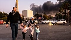 الدخان يتصاعد أثناء وصول الناس للاحتفال بسقوط الحكومة السورية، في دمشق، سوريا، الأحد، 8 ديسمبر/كانون الأول 2024. 