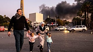 الدخان يتصاعد أثناء وصول الناس للاحتفال بسقوط الحكومة السورية، في دمشق، سوريا، الأحد، 8 ديسمبر/كانون الأول 2024. 