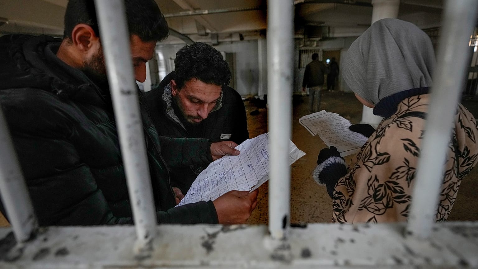 أشخاص يتفقدون الوثائق التي عثروا عليها في سجن صيدنايا العسكري سيء السمعة، شمال دمشق، سوريا، الاثنين، 9 ديسمبر/كانون الأول 2024