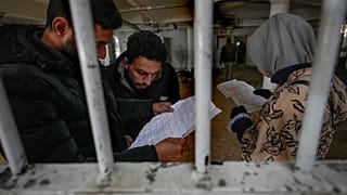 أشخاص يتفقدون الوثائق التي عثروا عليها في سجن صيدنايا العسكري سيء السمعة، شمال دمشق، سوريا، الاثنين، 9 ديسمبر/كانون الأول 2024