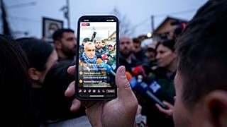 Ένας άνδρας καταγράφει βίντεο του Calin Georgescu, ανεξάρτητου υποψηφίου για την προεδρία που κέρδισε τον πρώτο γύρο των προεδρικών εκλογών, 8 Δεκεμβρίου 2024.