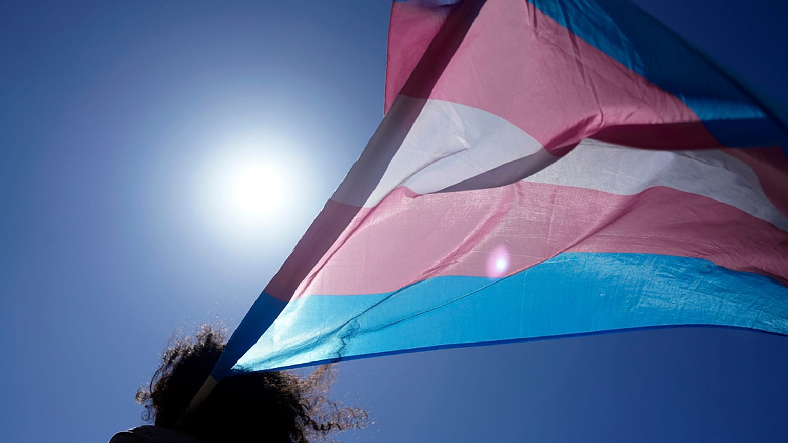 Una persona ondea la bandera trans
