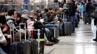 Viaggiatori in attesa alla stazione Centrale di Milano