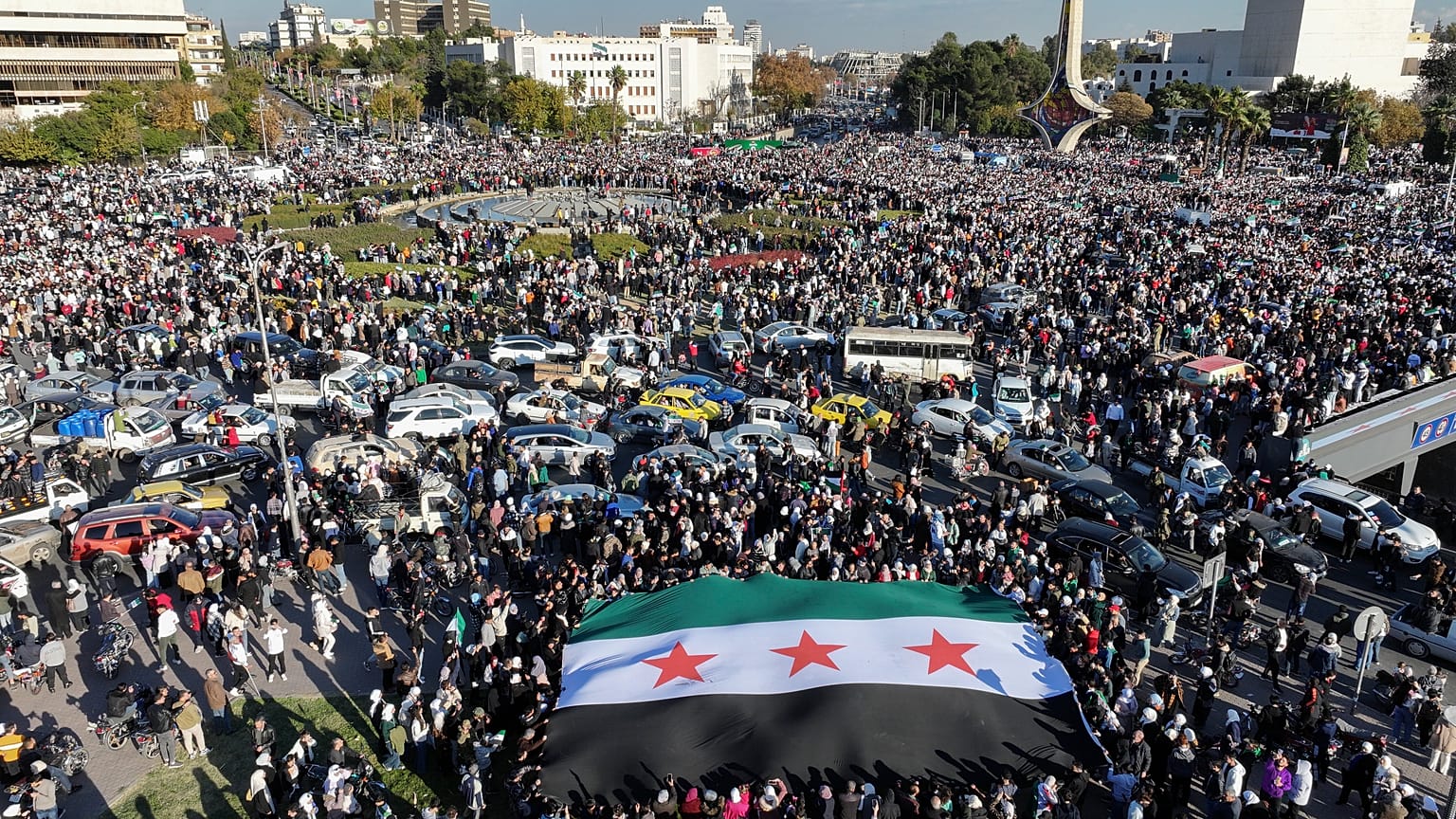 Siriani si riuniscono durante una manifestazione celebrativa dopo la prima preghiera del venerdì dalla cacciata di Bashar al-Assad a Damasco, 13 dicembre 2024