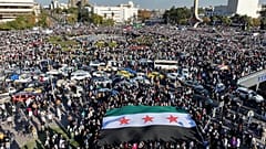Des Syriens se rassemblent lors d'une manifestation de célébration après la première prière du vendredi depuis l'éviction de Bashar al-Assad à Damas, 13 décembre 2024.
