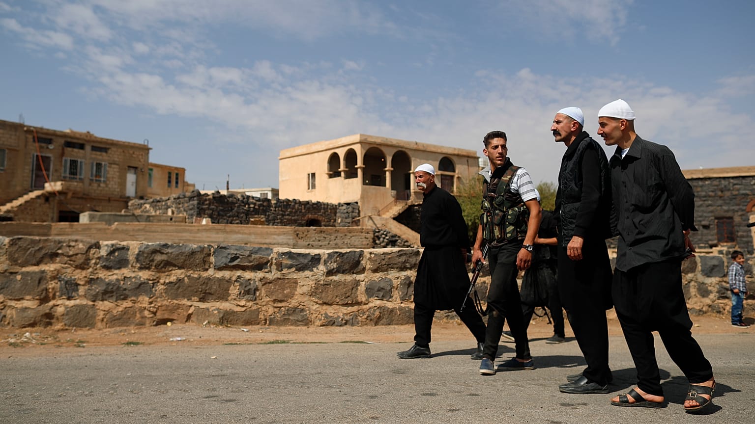 رجال دروز يسيرون في قرية الرامي في محافظة السويداء جنوب سوريا، الخميس، 4 أكتوبر/تشرين الأول 2018