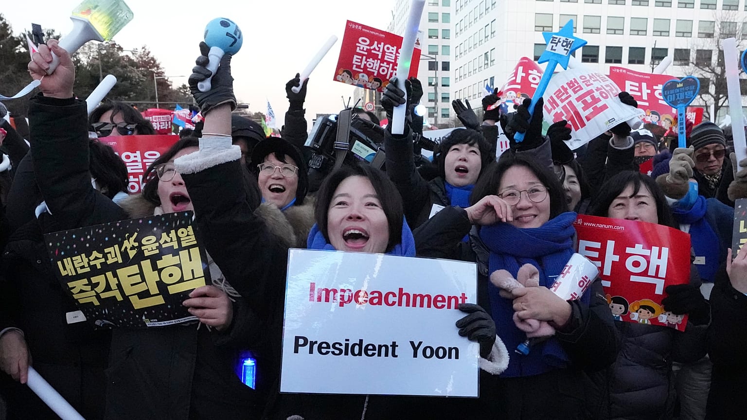 Participants react after hearing the news that South Korea's parliament voted to impeach President Yoon Suk Yeol outside the National Assembly in Seoul