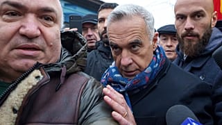 Calin Georgescu a sajtó képviselőitől körülvéve halad a lezárt szavazóhelyiség felé, miután a román alkotmánybíróság megsemmisítette az elnökválasztás első fordulóját.