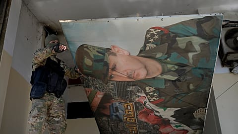 Suriyeli bir isyancı Şam'da eski Devlet Başkanı Beşar Esad'ın posterini kaldırıyor, 14 Aralık, 2024