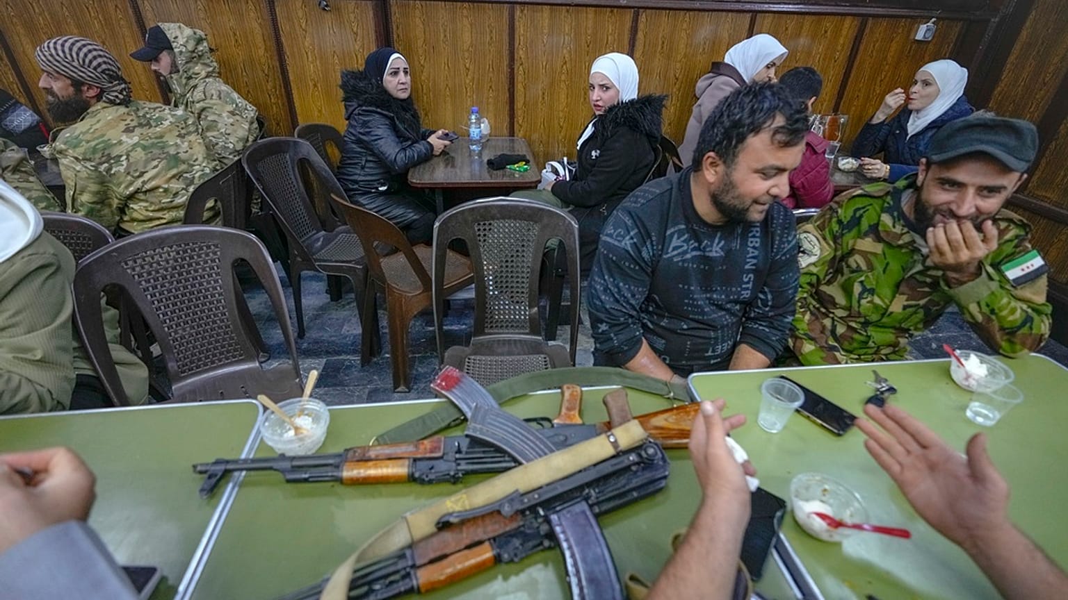 DATEI - Oppositionskämpfer sitzen in einem Restaurant auf dem Al-Hamidiyeh-Markt in der alten Stadtmauer von Damaskus, Syrien, Dienstag, 10. Dezember 2024. (AP Photo/Hussein Malla)