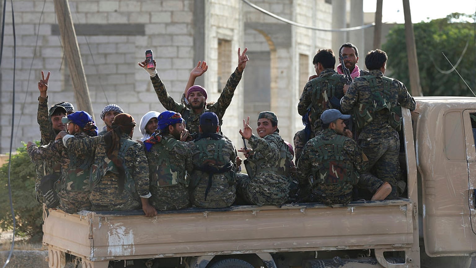 FILE - 2017. július 22. Az Egyesült Államok által támogatott Szíriai Demokratikus Erők (SDF) arab és kurd harcosai gyülekeznek egy kisteherautón, miközben az Iszlám Állam elleni frontvonalhoz vonulnak.