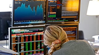 A fund manager looks at screens displaying activities of shares on the French Stock Exchange, in a financial analysis office in Paris, France, Tuesday, Aug. 25, 2015. 