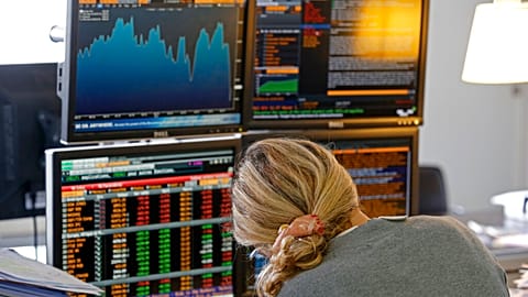 A fund manager looks at screens displaying activities of shares on the French Stock Exchange, in a financial analysis office in Paris, France, Tuesday, Aug. 25, 2015. 