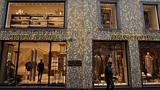 Un hombre pasa junto a una tienda en la calle Monte Napoleone, Milán, Italia.