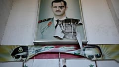 Um cartaz rasgado do falecido presidente sírio Hafez Assad e o seu filho, o presidente sírio deposto Bashar Assad, na entrada do famoso centro de detenção em Damasco.