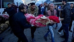 فلسطينيون يحملون جثمان أحد أقاربهم الذي قُتل في القصف الإسرائيلي على قطاع غزة في مستشفى في دير البلح، الأحد، 15 ديسمبر/كانون الأول 2024
