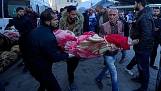 فلسطينيون يحملون جثمان أحد أقاربهم الذي قُتل في القصف الإسرائيلي على قطاع غزة في مستشفى في دير البلح، الأحد، 15 ديسمبر/كانون الأول 2024