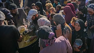 فلسطينيون يتجمعون للحصول على الطعام المتبرع به في مركز توزيع في دير البلح بقطاع غزة، الثلاثاء 17 ديسمبر/كانون الأول 2024.