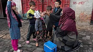 عاملة في المجال الصحي تعطي لقاح شلل الأطفال لطفلة في باكستان في كانون الأول ديسمبر 2024