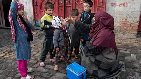 A health worker administers a polio vaccine to a child in Pakistan in December 2024.