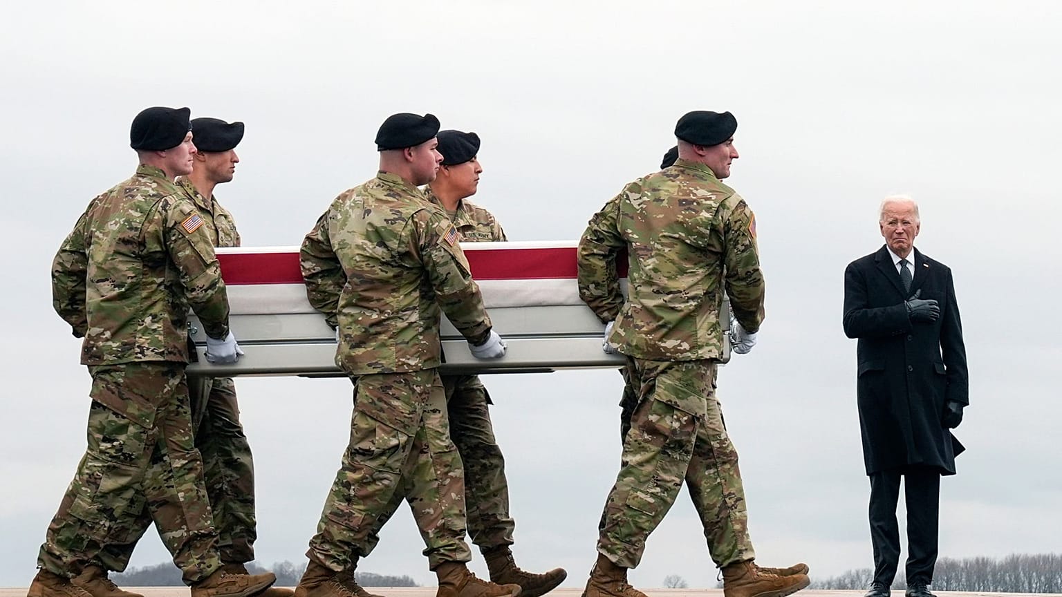 Le président Joe Biden, à droite, se tient debout alors qu'une équipe de transport de l'armée déplace la caisse de transfert contenant la dépouille du sergent Kennedy Ladon Sanders, 24 ans, le 2 février 2024.