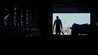 Contract worker from Mexico, carries tools back while doing maintenance inside a tobacco barn 