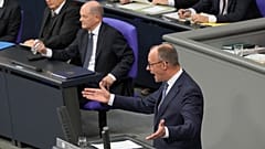 El líder de la oposición Friedrich Merz, a la derecha, de la CDU, habla mientras el Canciller alemán Olaf Scholz, en el centro, observa durante una sesión plenaria en el Parlamento alemán Bundestag.