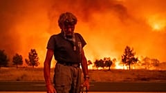 Grant Douglas faz uma pausa durante a evacuação enquanto o incêndio de Park Fire salta a autoestrada 36, perto de Paynes Creek, no condado de Tehama, Califórnia.