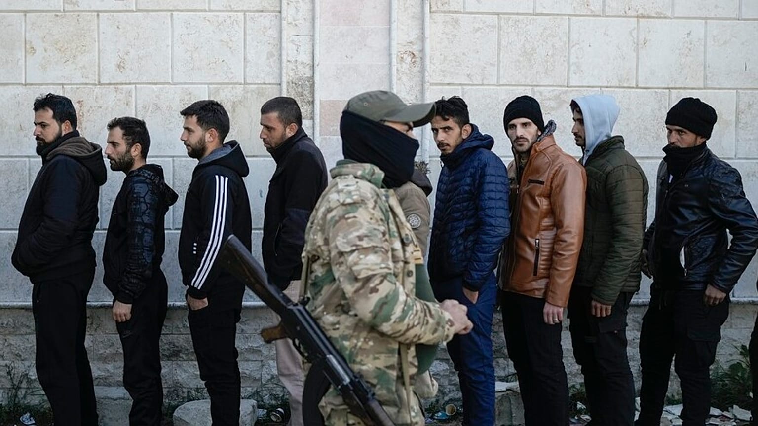 Miembros del periodo del ejército sirio de Bashar Assad hacen cola para registrarse con los rebeldes sirios como parte de un "proceso de identificación y reconciliación" en un complejo del ejército en Latakia.