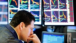 A specialist studies his screens as he works on the floor of the New York Stock Exchange, Friday, Oct. 10, 2008.